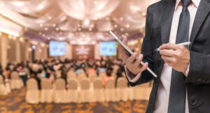 A man with a tablet standing in front of an event.